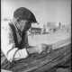 Proprio un baffutto pescatore non sfugge all�occhio attento del fotografo, mentre � intento a intrecciare con pazienza le sue reti davanti al mare

(F. Alexander Turnbull Library, Welligton, NZ. Ref. DA-04515-F)